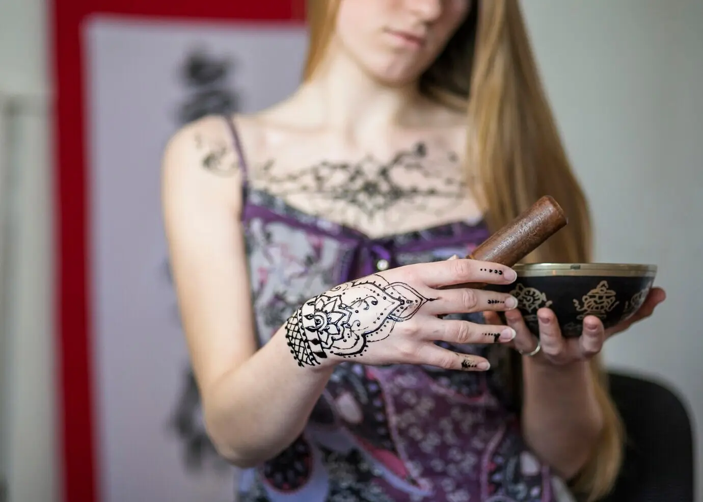 Nahaufnahme einer Frau, die einen Holzklöppel über der Klangschale schlug.